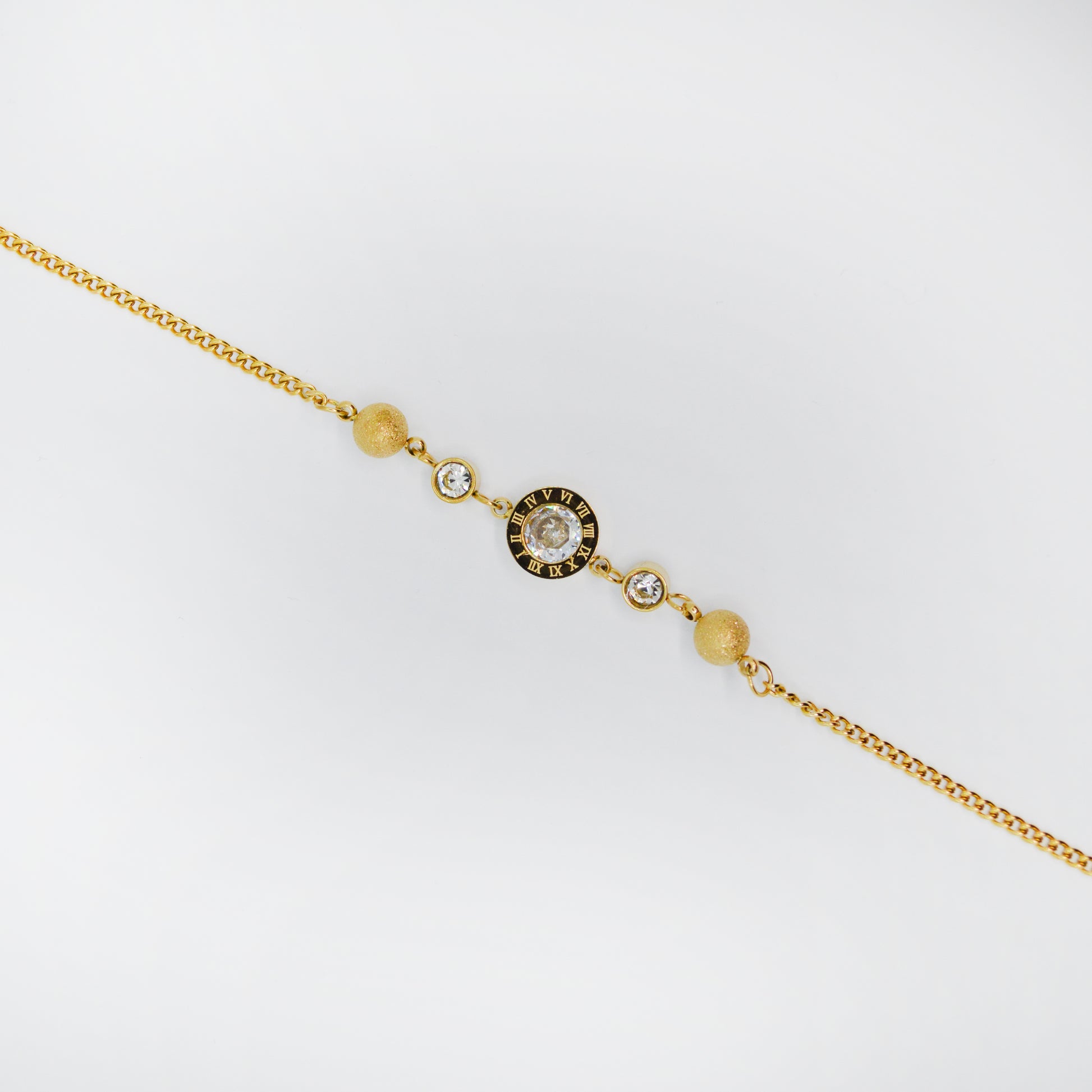 Zapestnica Roma Charm v zlati barvi z rimskimi številkami in osrednjim cirkonom.
