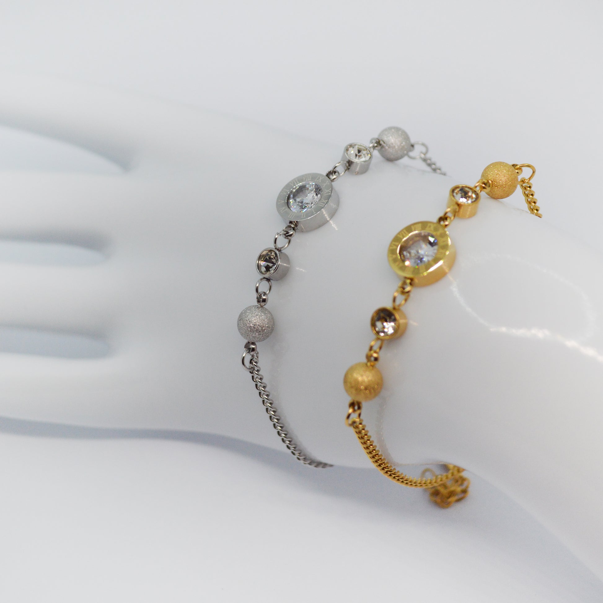 Zapestnici Roma Charm v srebrni in zlati barvi z rimskimi številkami.